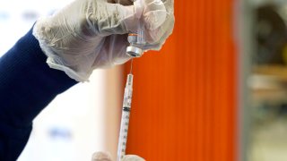 A nurse loads a syringe with the child's dose of the Pfizer COVID-19 vaccine prior to vaccinating a Jackson Public School student at a vaccination station in Jackson, Miss., Feb. 16, 2022.