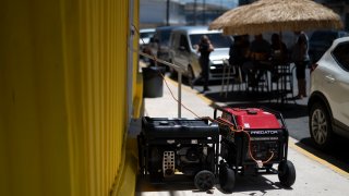 Business owners turn to their power generators to be able to keep working during an island-wide blackout, in San Juan, Puerto Rico, Thursday, April 7, 2022. More than a million customers in Puerto Rico remained without electricity on Thursday after a fire at a main power plant caused the biggest blackout so far this year across the U.S. territory, forcing it to cancel classes and shutter government offices.