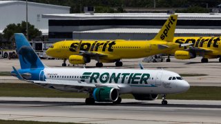 A Frontier Airlines plane near a Spirit Airlines plane at the Fort Lauderdale-Hollywood International Airport on May 16, 2022 in Fort Lauderdale, Florida.