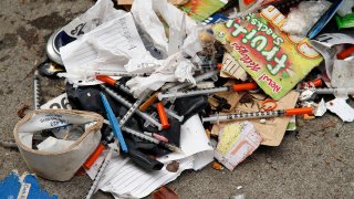 FILE - In this Feb. 26, 2016, file photo, syringes can be seen among the remains of a tent city being cleared by city workers along Division Street in San Francisco.