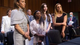 SImone Biles and her fellow gymnasts stand at the Larry Nassar trial