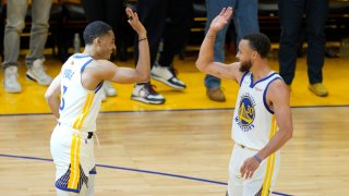 Jordan Poole #3 and Stephen Curry #30 of the Golden State Warriors high five.