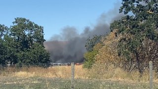 Fire involving greenhouses and brush near Morgan Hill.