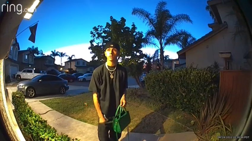 Adrian Rodriquez, of Chula Vista, waits to return a purse belonging to a woman who left it in the parking lot of a grocery store.