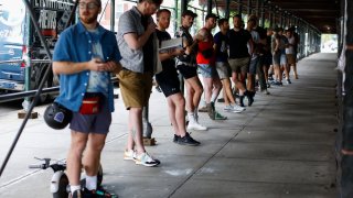 People wait in line to recieve the Monkeypox vaccine before the opening of a new mass vaccination site at the Bushwick Education Campus in Brooklyn on July 17, 2022, in New York City.