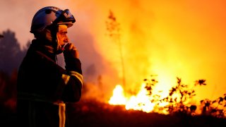 A firefighter works to contain a tactical fire in Louchats, as wildfires continue to spread in the Gironde region of southwestern France, July 17, 2022. 