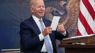 US President Joe Biden reacts to a note given to him saying that the CHIPS-plus bill has passed the House during a meeting with CEOs about the economy in the South Court Auditorium of the Eisenhower Executive Office Building, next to the White House, in Washington, DC on July 28, 2022.