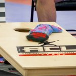 red and purple bean bags sit on a cornhole board with the 