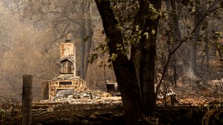 A chimney stands at a home destroyed by the McKinney Fire on Tuesday, Aug. 2, 2022, in Klamath National Forest, Calif.