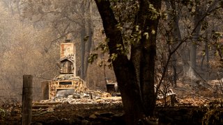 A chimney stands at a home destroyed by the McKinney Fire on Tuesday, Aug. 2, 2022, in Klamath National Forest, Calif.