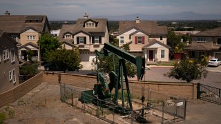 A pump jack extracts oil at a drilling site next to homes Wednesday, June 9, 2021, in Signal Hill, Calif. California legislators passed a bill, on Wednesday, Aug. 31, 2022, to ban new oil and gas wells within 3,200 feet of homes, schools and other neighborhood sites. It now goes to Gov. Gavin Newsom, who is expected to sign it.