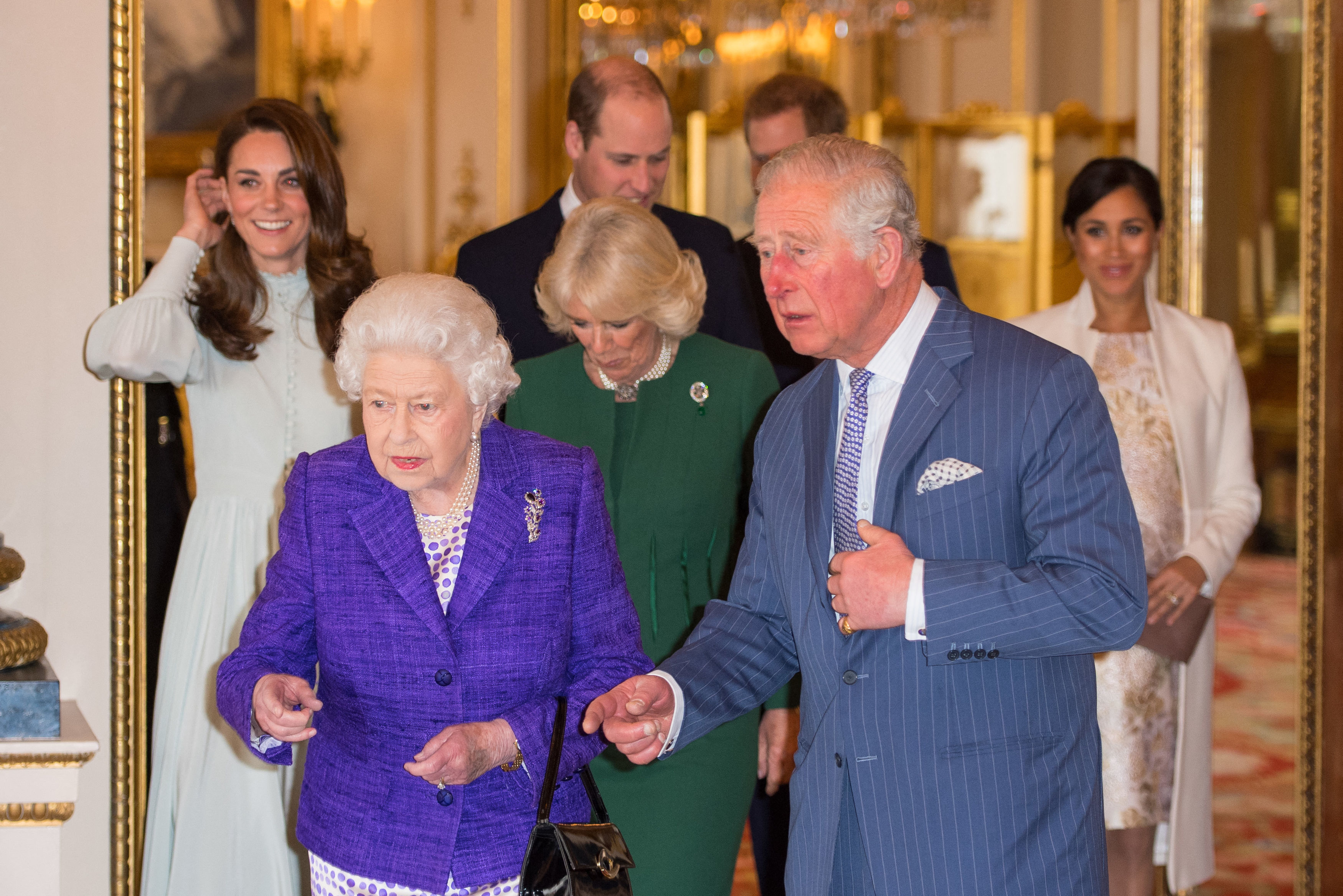 (L-R) Catherine, Duchess of Cambridge, Queen Elizabeth II, Prince William, Duke of Cambridge, Camilla, Duchess of Cornwall, Prince Charles, Prince of Wales, Prince Harry, Duke of Sussex, and Meghan, Duchess of Sussex attend a reception to mark the 50th anniversary of the investiture of the Prince of Wales at Buckingham Palace in London on March 5, 2019. The Queen hosted a reception to mark the 50th anniversary of the investiture of Prince Charles, her son, as the Prince of Wales.