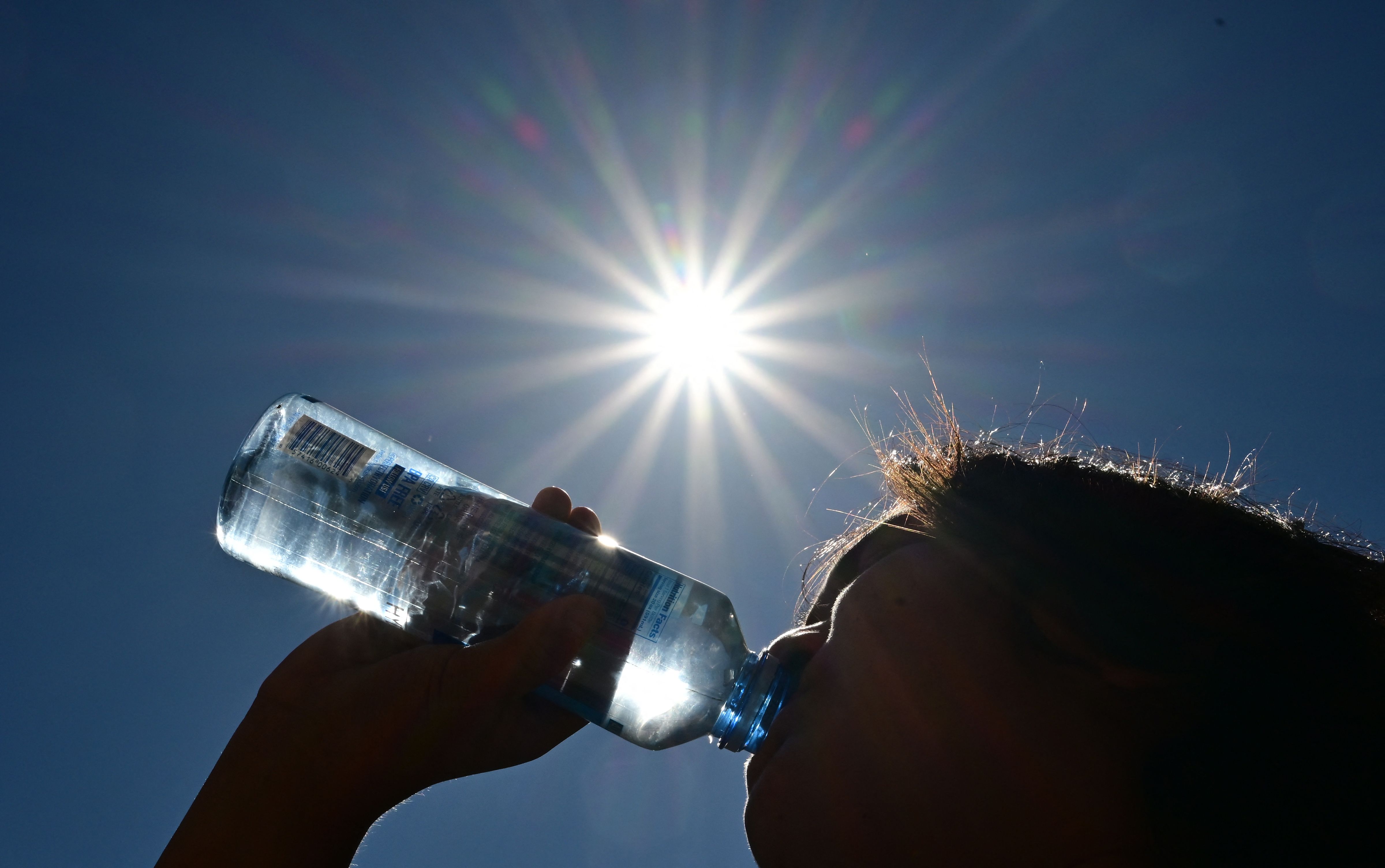A child sips water from a bottle.