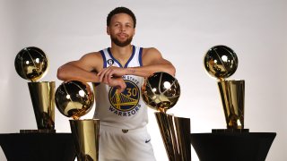 Stephen Curry #30 of the Golden State Warriors poses with the four Larry O'Brien Championship Trophies that he has won with the Warriors.