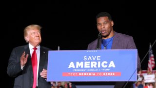 Former college football star and current senatorial candidate Herschel Walker speaks at a rally, as former U.S. President Donald Trump applauds, in Perry, Georgia, U.S. September 25, 2021.