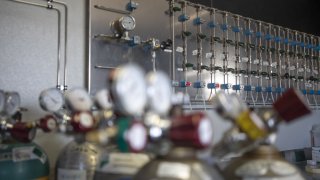 FILE - Helium tanks in front of the helium testing lab at the North American Helium Inc. purification plant in Battle Creek, Saskatchewan, Canada, on Wednesday, May 18, 2021.