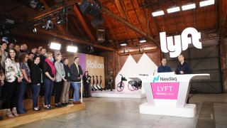 Lyft CEO Logan Green (R) and President John Zimmer (2nd R) speak before the Nasdaq opening bell celebrating the company’s initial public offering (IPO) on March 29, 2019 in Los Angeles, California.