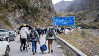 Russians cross the border between Russia and Georgia days after President Vladimir Putin announced a mobilization drive on September 21.