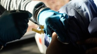 A Jackson-Hinds Comprehensive Health Center nurse administers a Pfizer COVID-19 booster vaccine at an inoculation station next to Jackson State University in Jackson, Miss., Nov. 18, 2022.