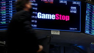 A screen displays the logo and trading information for GameStop on the floor of the New York Stock Exchange (NYSE) March 29, 2022.