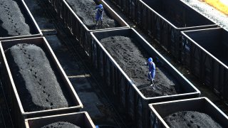 Workers photographed on top of a train loaded with coal in China. Global use of coal is projected to increase by 1.2% this year and hit a record high, according to the International Energy Agency.