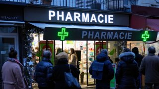 FILE - People wait in front of a pharmacy to get a COVID-19 test in Paris, France