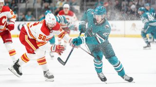 SAN JOSE, CA – DECEMBER 20: Oskar Lindblom #23 of the San Jose Sharks skates with the puck against MacKenzie Weegar #52 of the Calgary Flames at SAP Center on December 20, 2022 in San Jose, California. (Photo by Kavin Mistry/NHLI via Getty Images)