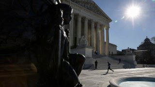 A person runs in front of the US Supreme Court in Washington, DC on December 28, 2022. – The US government two-year-old policy of invoking Covid-19 precautions to turn away hundreds of thousands of migrants at the Mexican border will remain in place for now, the Supreme Court ruled on December 27, 2022. (Photo by Oliver Contreras / AFP) (Photo by OLIVER CONTRERAS/AFP via Getty Images)