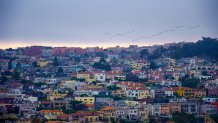 Summertime fog casts a gray shadow over homes in San Francisco's Richmond District at sunset.
