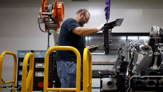 A worker assembles components on a diesel engine at the Cummins Seymour Engine Plant in Seymour, Indiana, on Monday, April 18, 2022.