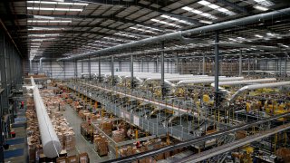 Workers work inside an Amazon.co.uk fulfillment centre in Hemel Hempstead, north of London, on November 25, 2015. The company has announced it will be closing the site.