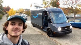 An Amazon DSP driver poses with his Rivian electric delivery van in Seattle, Washington, in November 2022.