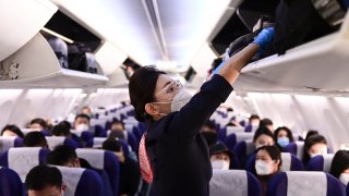 A flight attendant arranges suitcases at a plane at Ordos Ejin Horo International Airport on Jan. 7, 2023.