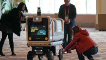 Members of the media photograph the Ottobot Yeti as it operates before the start of the CES tech show, Wednesday, Jan. 4, 2023, in Las Vegas. Ottonoy.IO launches Ottobot Yeti at CES 2023.