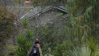 FILE – A guard stands on a closed street near the family home of FTX founder Sam Bankman-Fried in Palo Alto, Calif., on Dec. 23, 2022. In a letter from Bankman-Fried’s lawyers disclosed Thursday, Jan. 19, 2023, a car with three occupants recently drove into a barricade outside the home owned by Bankman-Fried’s parents, an apparent attempt to gain access to the property where the founder of crypto exchange FTX is under house arrest. (AP Photo/Jeff Chiu, File)