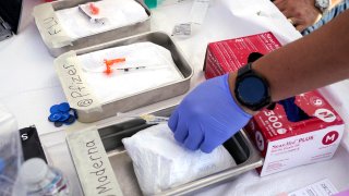 Syringes with vaccines are prepared at the L.A. Care and Blue Shield of California Promise Health Plans’ Community Resource Center where they were offering members and the public free flu and COVID-19 vaccines Friday, Oct. 28, 2022, in Lynwood, Calif.