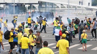 Supporters of Brazilian former President Jair Bolsonaro clash with the police during a demonstration outside the Planalto Palace