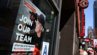 A sign for hire is posted on the window of a Chipotle restaurant in New York, April 29, 2022.