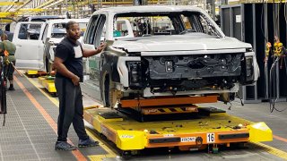 Ford workers produce the electric F-150 Lightning pickup on Dec. 13, 2022 at the automaker’s Ford Rouge Electric Vehicle Center (REVC).