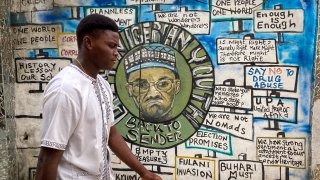 A man walks past an artist’s mural, painted for a previous election and showing incumbent President Muhammadu Buhari, in Lagos, Nigeria Friday, Feb. 24, 2023.