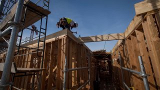 A worker builds framing during construction on a project for affordable housing.