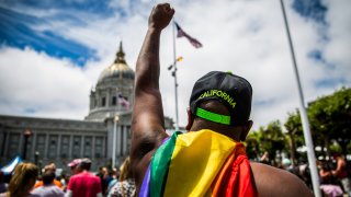 A person salutes City Hall after the San Francisco Gay Pride Parade.