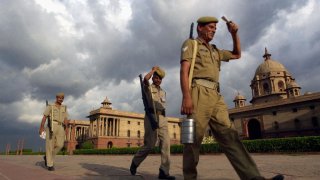 Indian guards of Central Industrial Security Force (CISF) change shifts as monsoon clouds cover the skyline over South Block (The Defence Ministry) in New Delhi 27 July 2003.