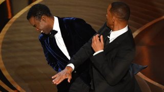 FILE - Will Smith (R) slaps Chris Rock onstage during the Oscars ceremony at the Dolby Theatre in Hollywood, Calif., on March 27, 2022.