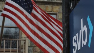 A U.S. flag flies outside a branch of the Silicon Valley Bank in Wellesley, Massachusetts, U.S., March 13, 2023. 