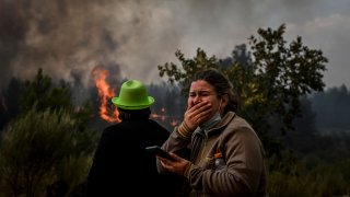 A local reacts to watching a wildfire advancing in Orjais, Covilha council in central Portugal, on August 16, 2022.