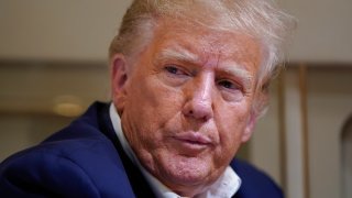 Former President Donald Trump listens as he speaks with reporters while in flight on his plane after a campaign rally at Waco Regional Airport, in Waco, Texas, Saturday, March 25, 2023, while en route to West Palm Beach, Fla.