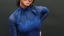 A photo of Brooke Jeffrey wearing a blue leotard and posing against a dark background.