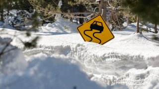 Sign nearly blocked by snowfall.