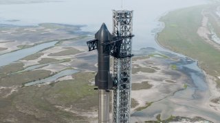 A Starship prototype is seen stacked on top of a Super Heavy booster at the company’s launch facility near Brownsville, Texas.
